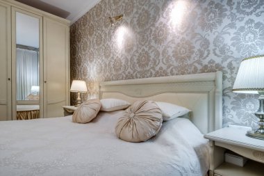 Stüdyo dairelerde açık renkli yastıklı modern lüks yatak odasının içinde.