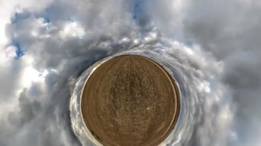 Karanlık kürenin soyut spiral dönüşü bulutlarla kaplanmış gökyüzünde dönüyor. Küçük gezegen döngüsü. 