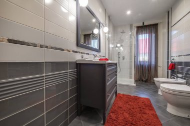 Duş kabini duvarına monte edilmiş tuvalet ve detaylar