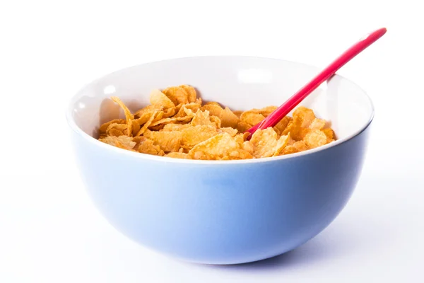 Tazza blu con cucchiaio rosso tra i cereali Foto Stock