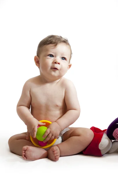 Satisfecho niño de 8 meses sentado con sus juguetes aislados en — Foto de Stock