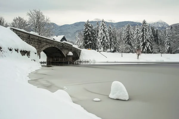 Stenen brug in de winter met bevroren meer — Stockfoto