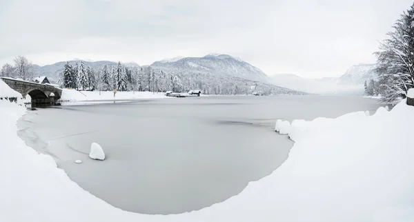 Winterlandschap met stenen brug en bevroren meer in de sloven — Stockfoto