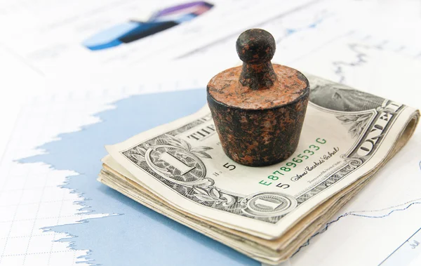Financial concept. Old rusty weight on money and diagrams. — Stock Photo, Image