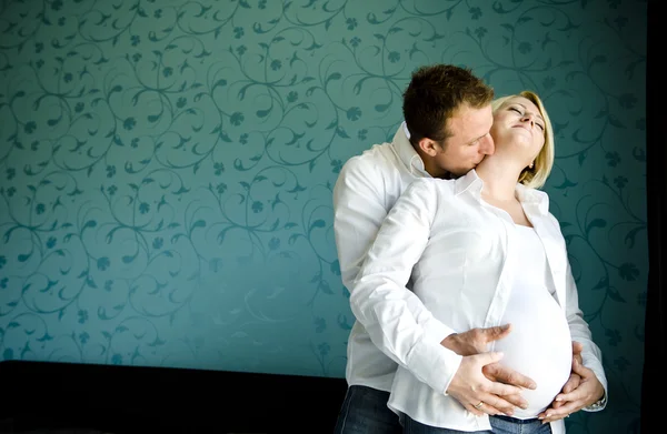 Portrait of a happy pregnant couple the men kissing the girl nec — Stock Photo, Image