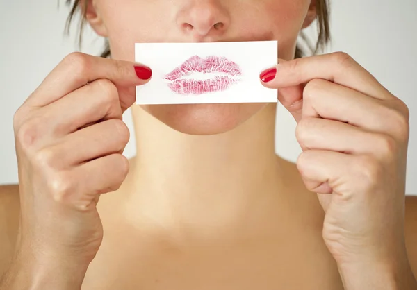 Aantrekkelijk meisje houdt dat haar lippen afdrukken tegen haar mond. — Stockfoto