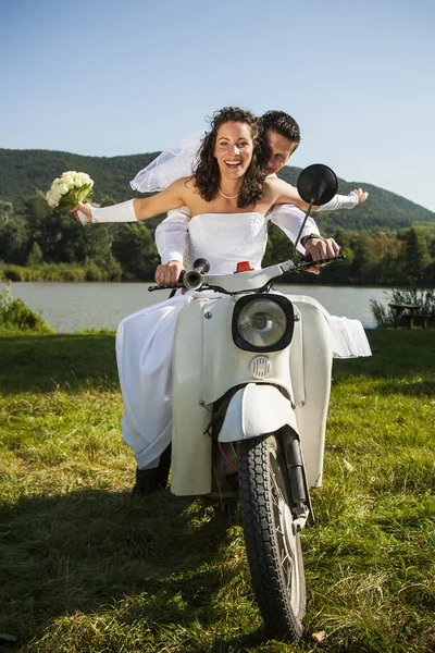 Happy wedding couple take a ride in a white motorcycle. — Stock Photo, Image