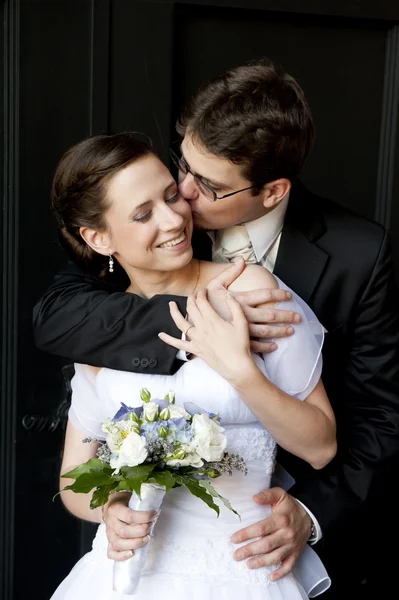 年轻的新郎抱着美丽的新娘，亲吻她. — 图库照片
