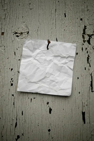 Grungy torn note paper nailed on rustic old weathered background — Stock Photo, Image