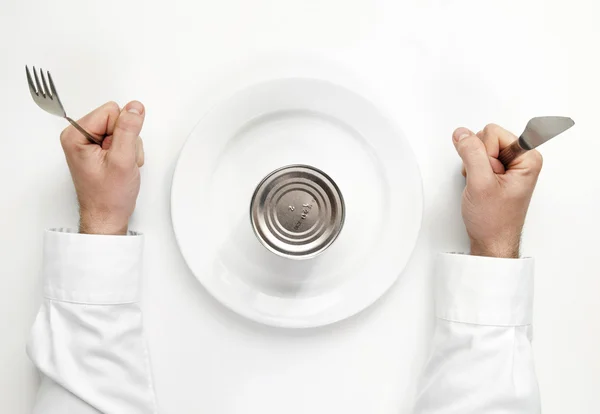 Conceito de fome. caixa de lata não aberta com as mãos humanas segurando garfo um — Fotografia de Stock