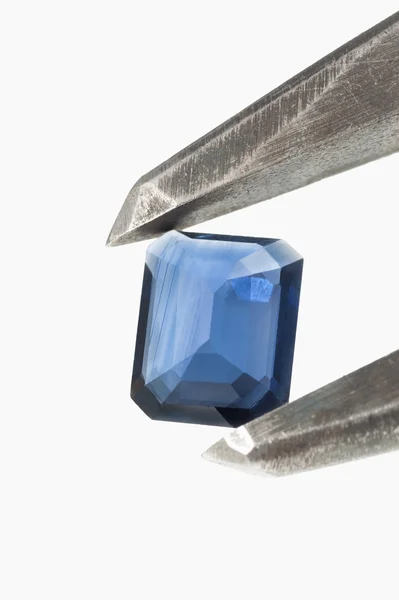 Blue topaz gem in caliper isolated with copy space. — Stock Photo, Image