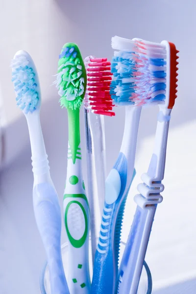 Toothbrushes in glass on white — Stock Photo, Image