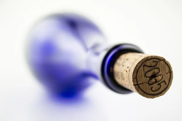 Wijn in blauwe fles geïsoleerd op witte achtergrond — Stockfoto