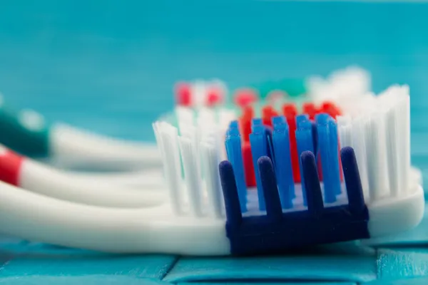 Colorful toothbrushes isolated on blue background — Stock Photo, Image