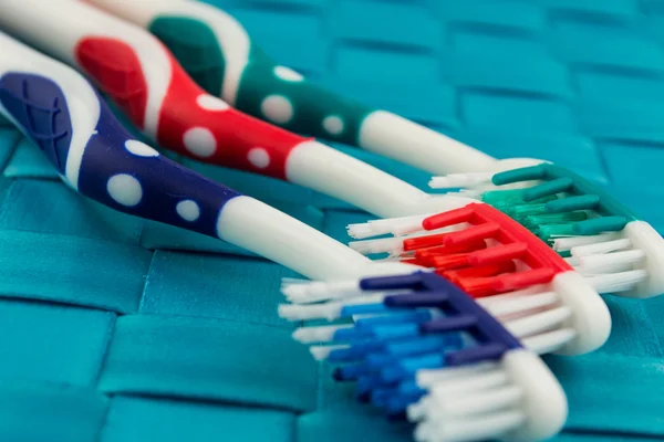 Cepillos de dientes coloridos aislados sobre fondo azul — Foto de Stock