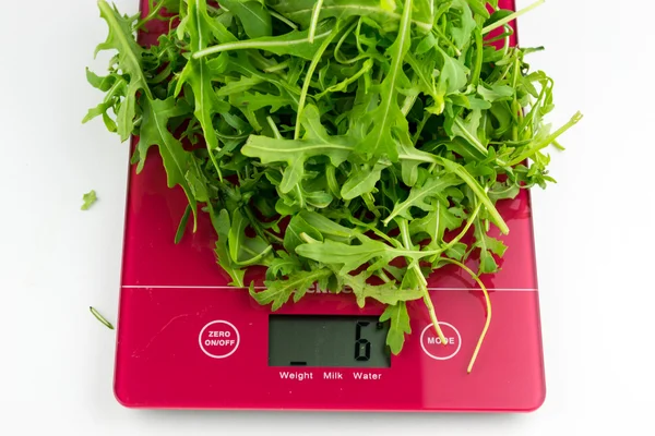 Arugula on kitchen scales — Stock Photo, Image