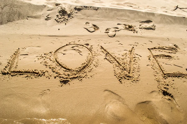 Ritning älskar ordet på stranden — Stockfoto