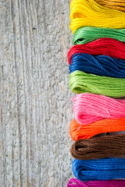 Fios de artesanato de algodão colorido em fundo de madeira com espaço de cópia — Fotografia de Stock