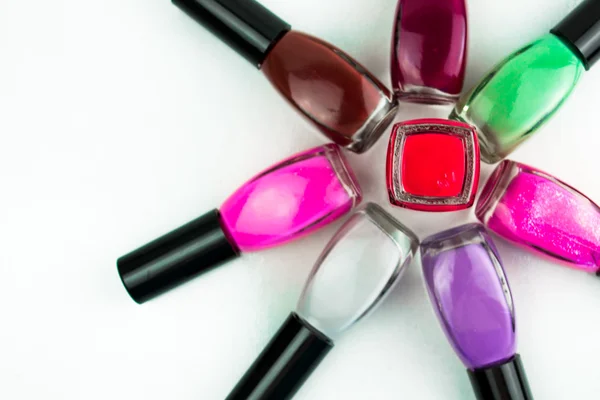 Coloured nail polish bottles stacked circle on a white background — Stock Photo, Image