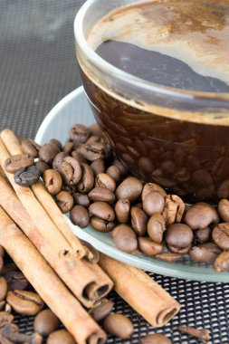bir fincan kahve kahve çekirdekleri ve tarçın