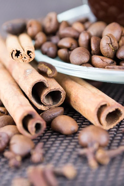 Eine Tasse Kaffee mit Kaffeebohnen und Zimtstangen — Stockfoto