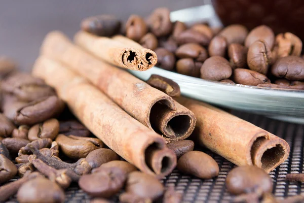 Una taza de café con granos de café y palitos de canela — Foto de Stock