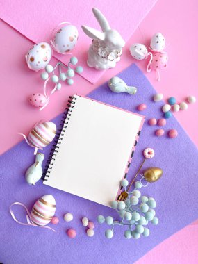 Pembe Masaüstü. Paskalya süslemeleri ile birlikte defter masanın üstünde. Çerçeve kenar düz üst görünüm kopyala. 