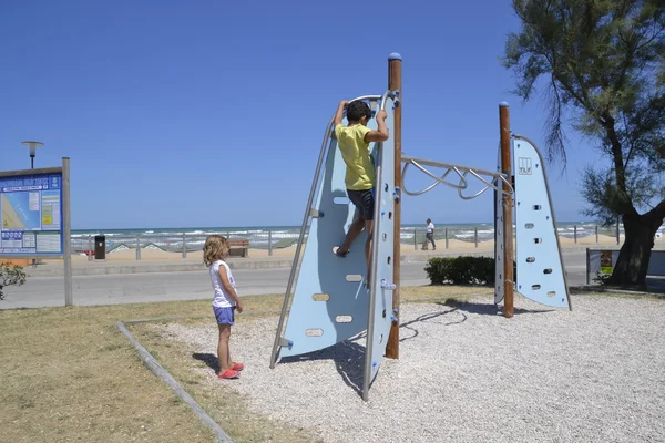 Les enfants jouent dans une aire de jeux près de la plage — Photo