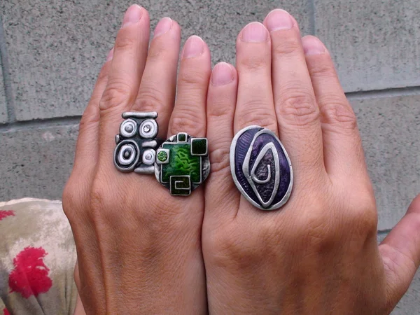 Parmaklarını geniş halkaları iki kadın eli