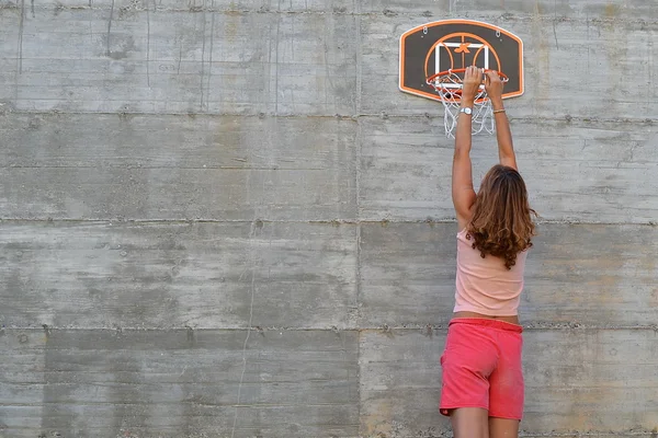 Mulher se estende sobre uma cesta de basquete — Fotografia de Stock