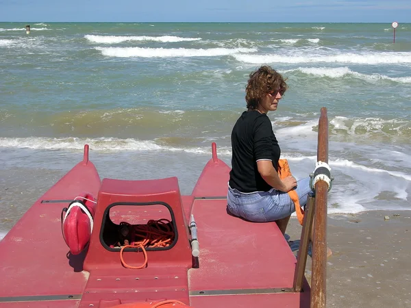 Γυναίκα που κάθεται στην άκρη του μια βάρκα στην παραλία — Φωτογραφία Αρχείου