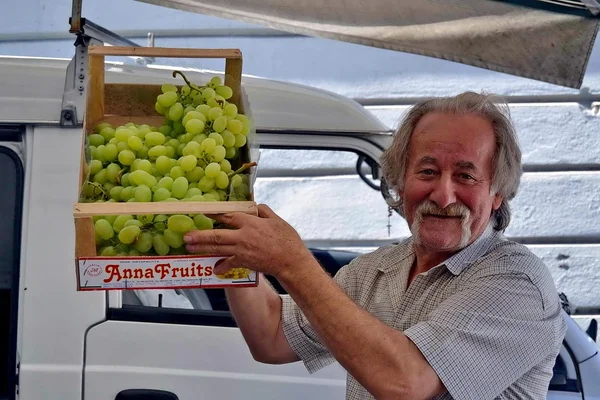 Seller of fruits and vegetables. market. grapes. peppers. onions. peschre. — Stock Photo, Image