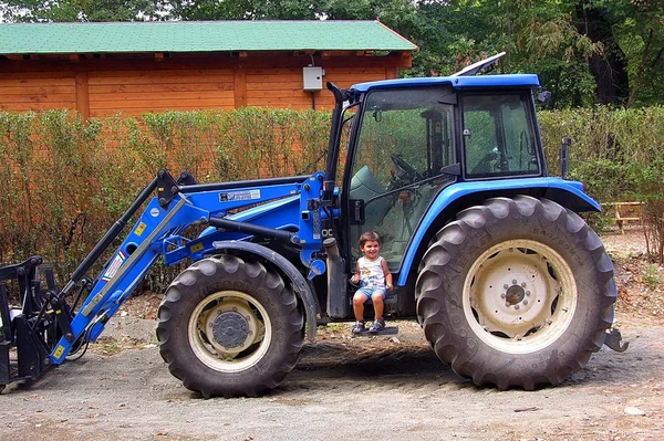 Το μεγάλο τρακτέρ και το μωράκι. εργασία. γεωργία. — Φωτογραφία Αρχείου