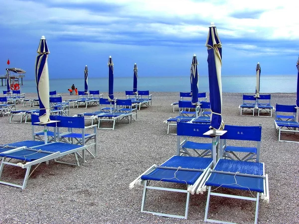 Ligstoelen. palmbomen. strand. wegen. steegjes. bogen. Ligurië. Italië. buiten. vakantie. ontspanning. — Stockfoto