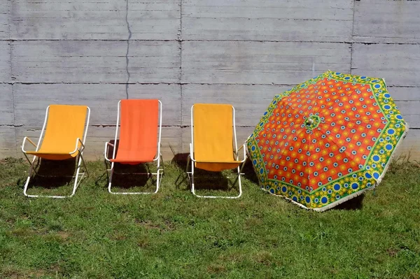 Sateenvarjo ja kansituolit. värit. Kesällä. Aurinko. Rentoutuminen — kuvapankkivalokuva