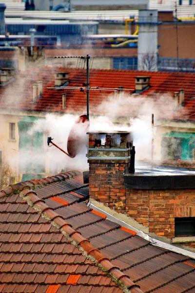 Öppen spis. rök. vinter. hus. taket. kallt. uppvärmning. moln. — Stockfoto