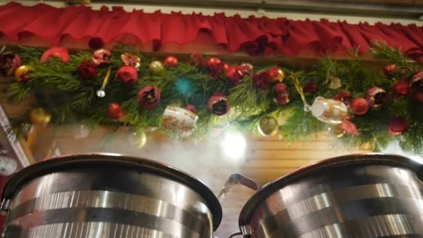 Warme wijn, glühwein tegen de achtergrond van nieuwjaarsdecoraties. Eerlijk in de stad. Close-up — Stockvideo