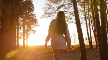 Güzel ve mutlu genç bir kadın olumlu duygularla ormanda dönüyor.