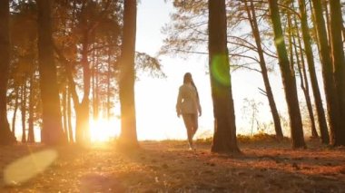 Güzel ve mutlu genç bir kadın olumlu duygularla ormanda dönüyor.