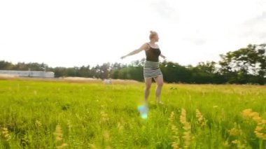 Güzel sarışın yeşil alanda dönüyor.