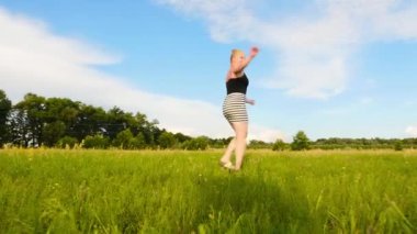 Güzel kız yaz mevsiminde yeşil alanda daireler çizer