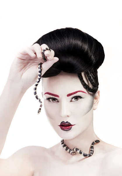 Женщина с творческим макияжем и змеей в руках — стоковое фото