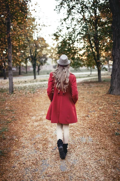 Sonbaharda parkta yürüyen bir kadın.