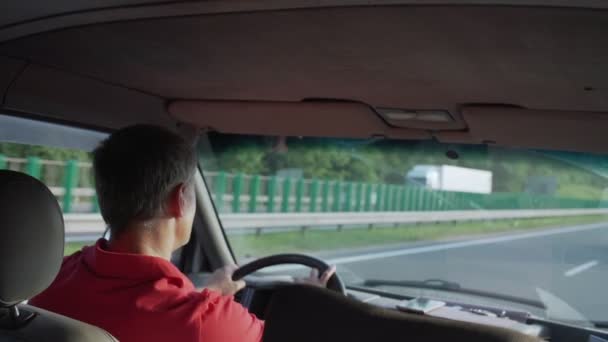 赤いジャージーに集中した男が夏に高速道路で車を運転し — ストック動画