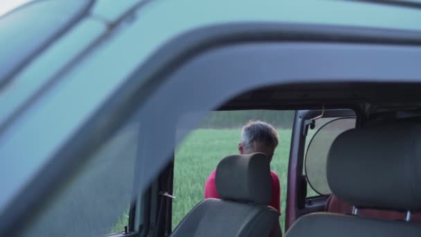 Hombre en jersey rojo toma la guitarra de minivan y cierra la puerta — Vídeos de Stock