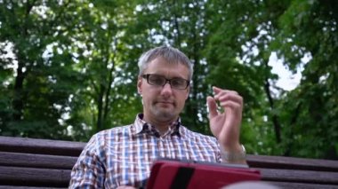 Adam tabletteki sosyal ağları kontrol ederken gözlüklere bakıyor.