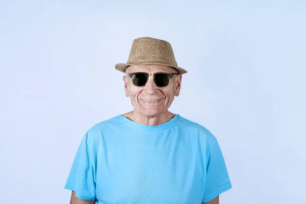 Boldog idős férfi kalapban és fekete napszemüvegben mosolyog foggal. — Stock Fotó