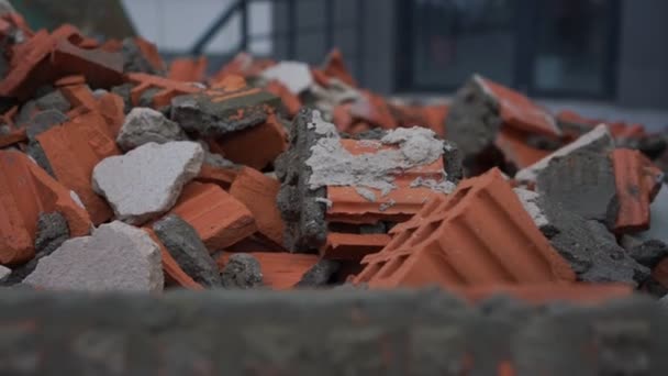 Stapel van oranje baksteen puin tegen de bouw gebouw — Stockvideo