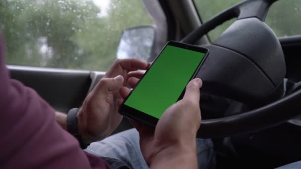 Conductor sostiene teléfono moderno con pantalla verde con maqueta de cromakey — Vídeos de Stock