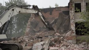 Büyük demir kürekli tırtıl traktörü inşaat enkazı temizliyor..
